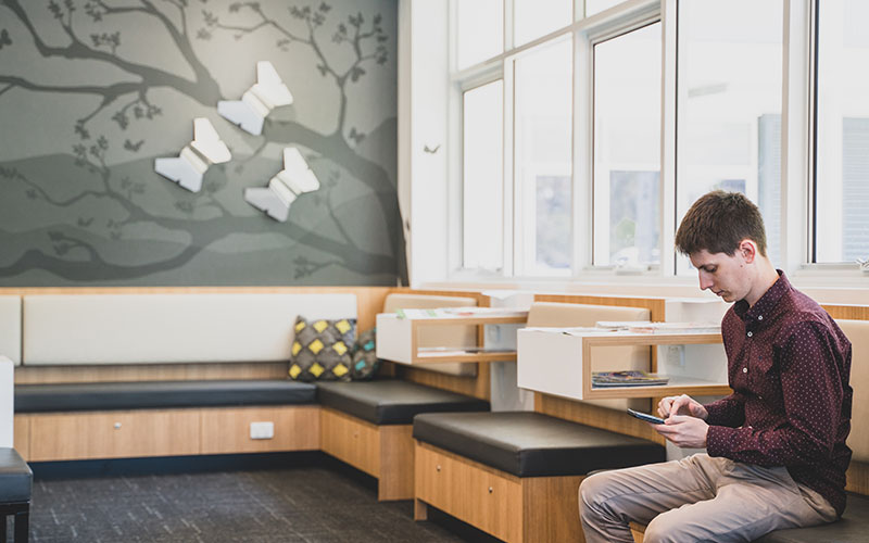 A waiting room of a medical practice with a patient on his phone