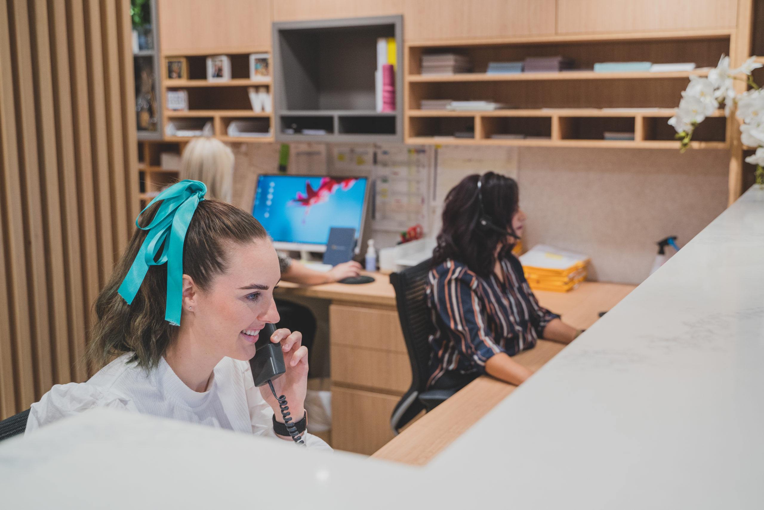 Clinic staff taking calls and working on Genie Solutions practice management software