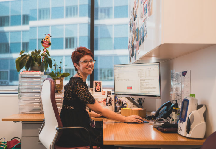 Practice manager sitting at computer using genie solutions software