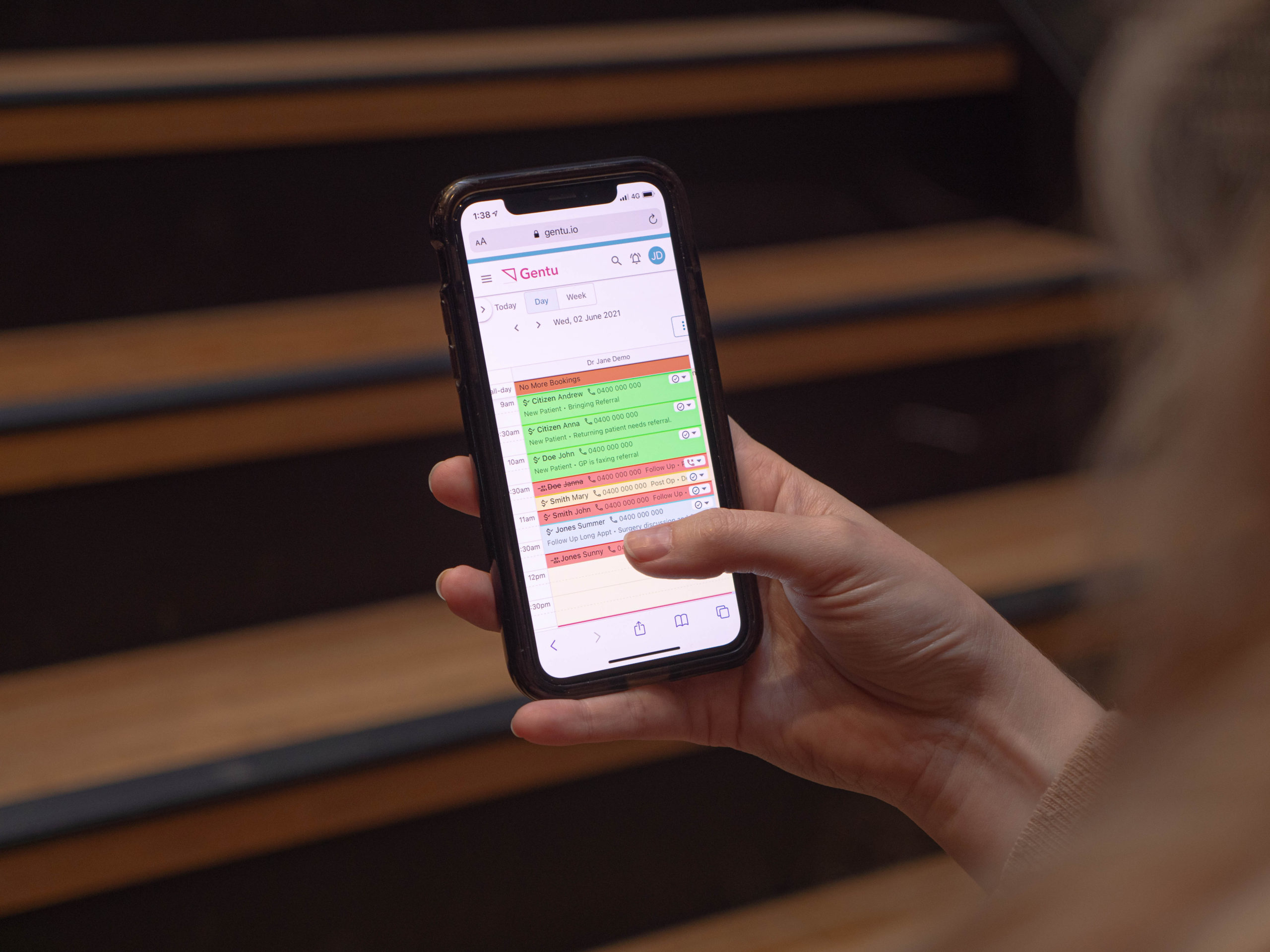 Person on phone with a close up of gentu practice management software on screen