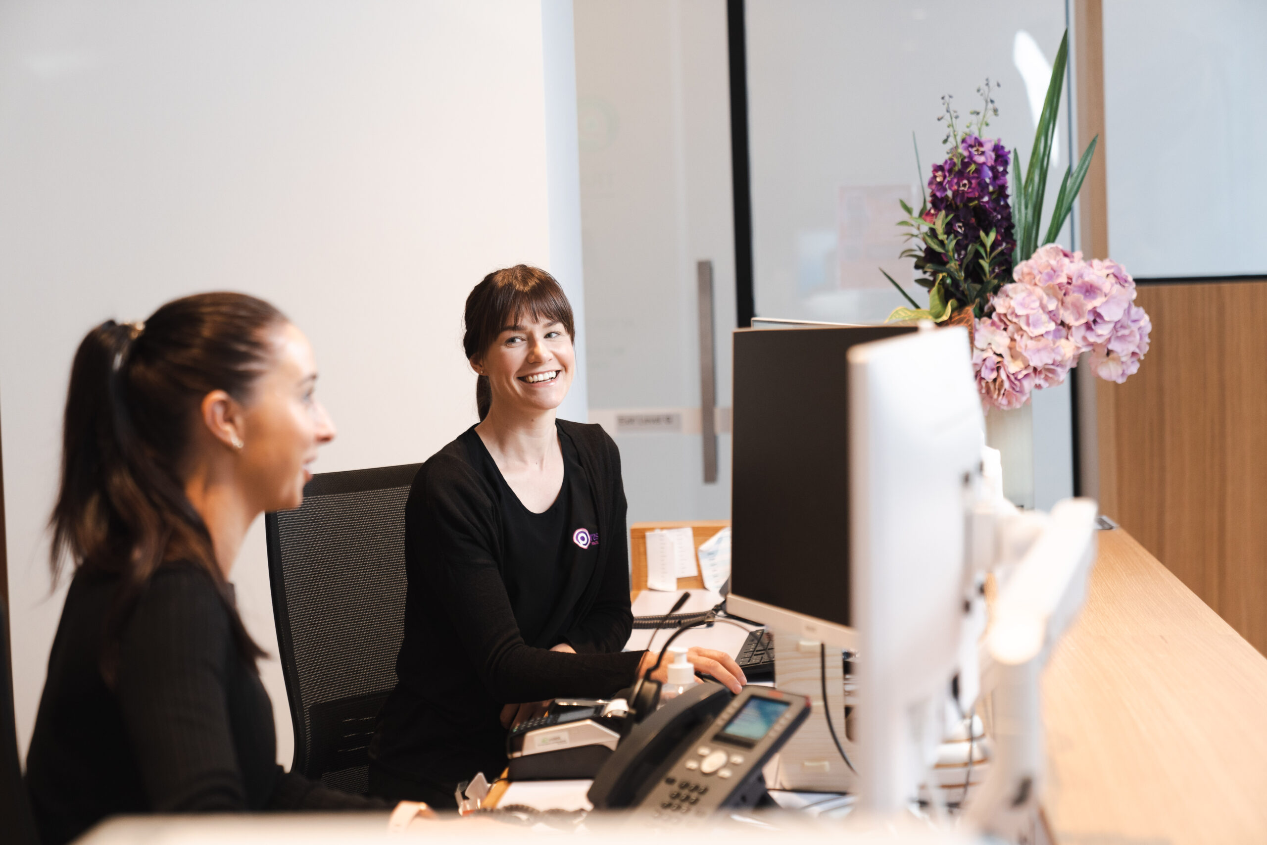 Practice staff sitting at clinic administration desk