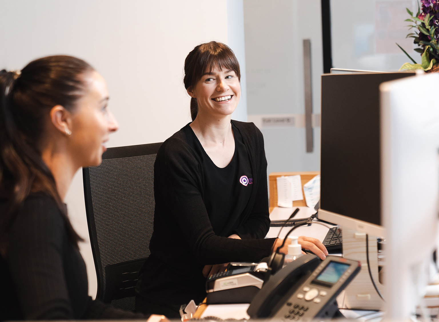 Practice staff sitting at clinic administration desk