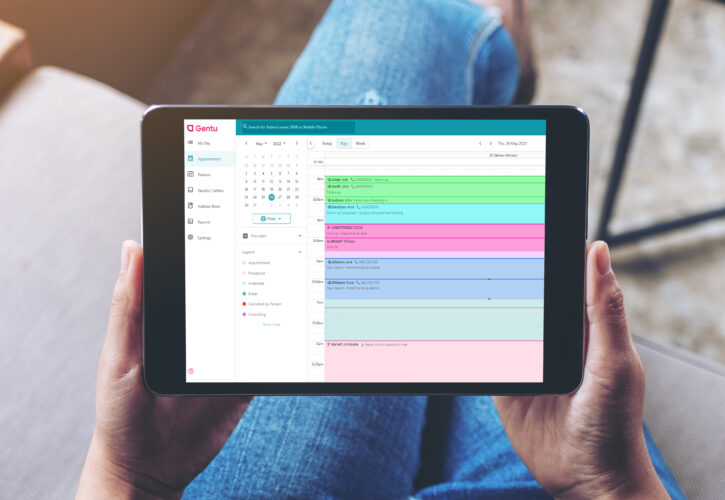 Specialist holding ipad with gentu practice management software on the screen
